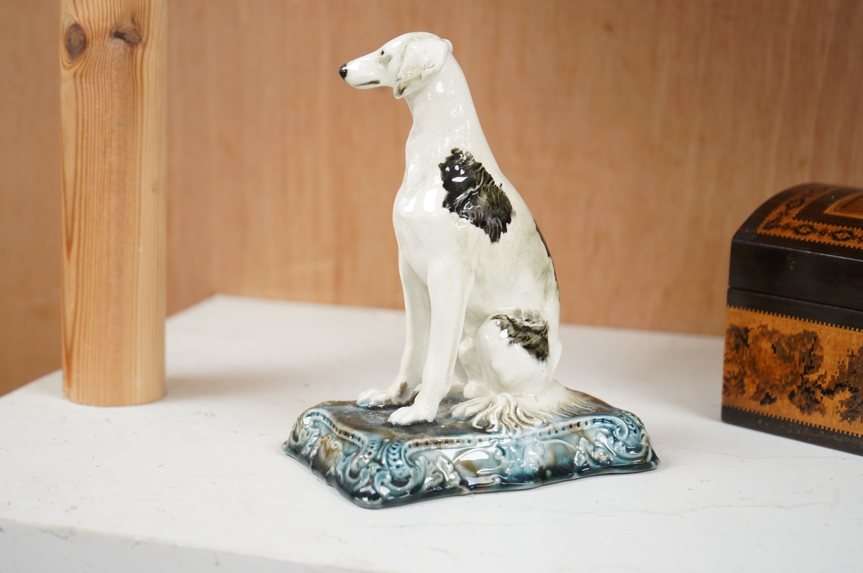 A Minton’s glazed pottery model of a seated Saluki, c.1905, stamped to the base, 15cm high